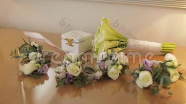 漂亮的结婚花束躺在桌子上，靠近盒子，里面有结婚戒指